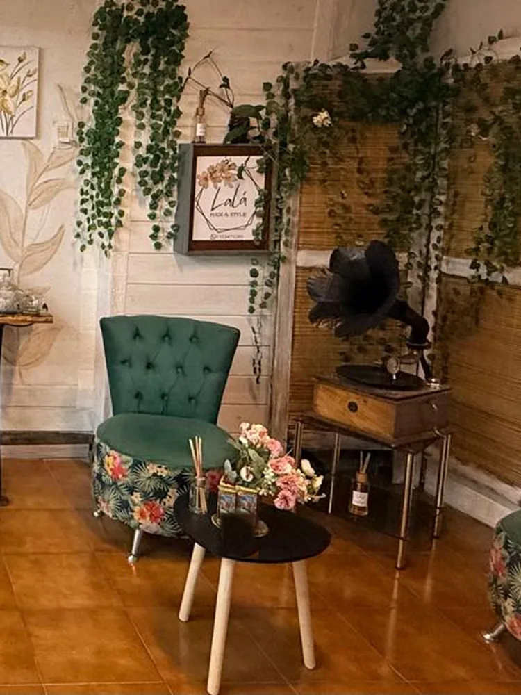 Sillones verdes con estampado floral y pared de enredaderas